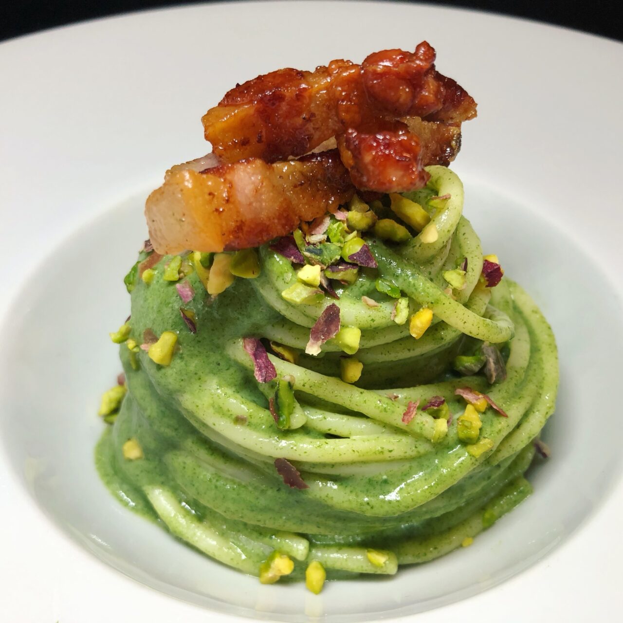 Spaghetti con agretti, guanciale e pistacchi