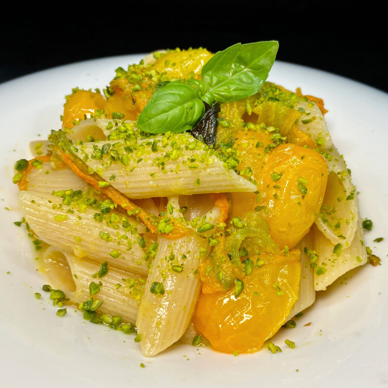 Penne Summer con pomodorini gialli, fiori di zucca, basilico e granella di pistacchio