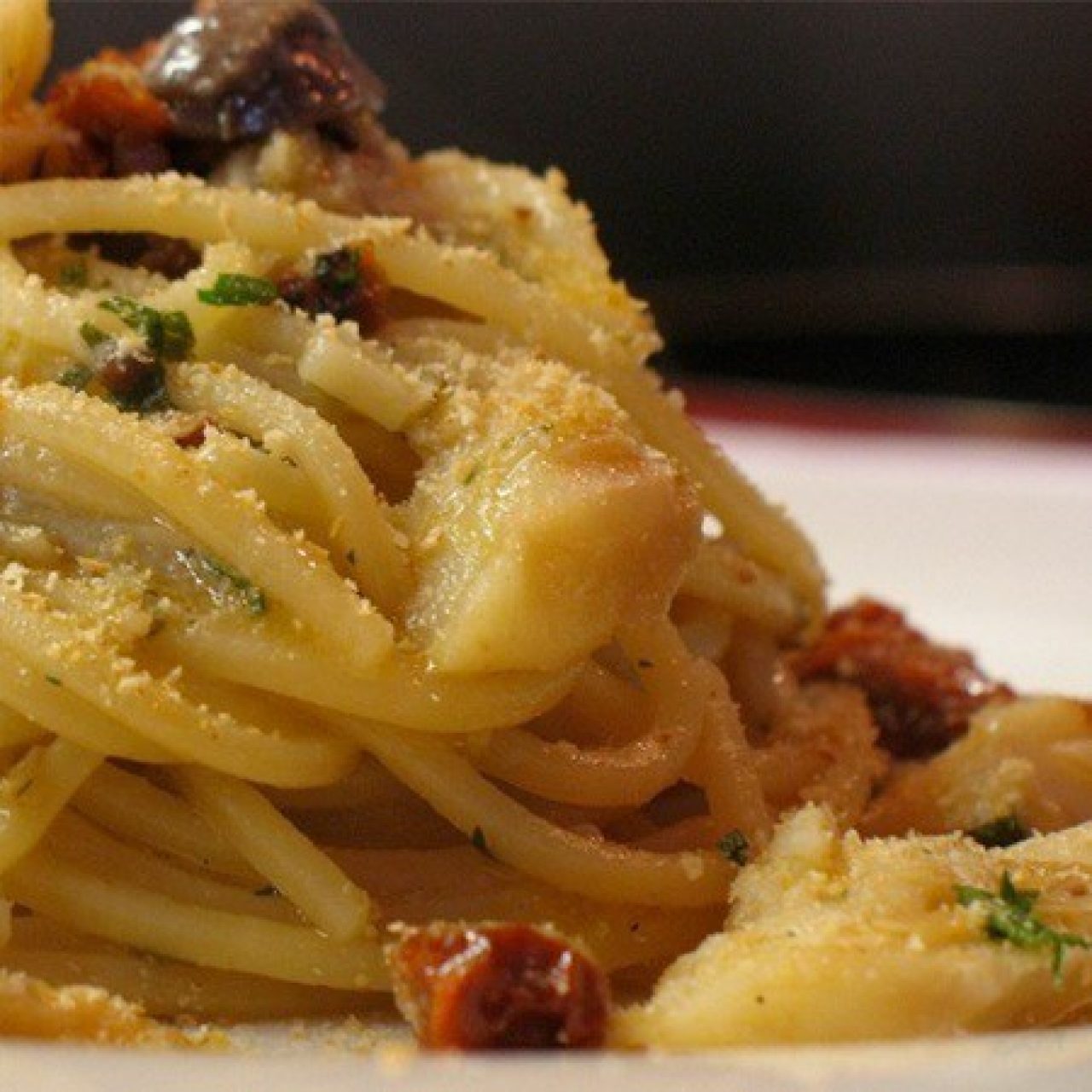 Spaghetti con baccalà, olive, capperi, e pomodori secchi