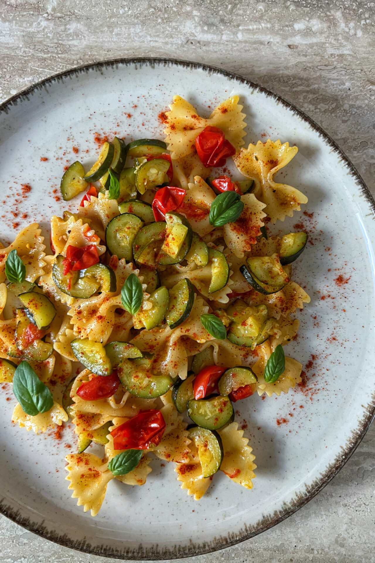 Farfalle con zucchine, pomodorini, basilico e polvere di peperoni