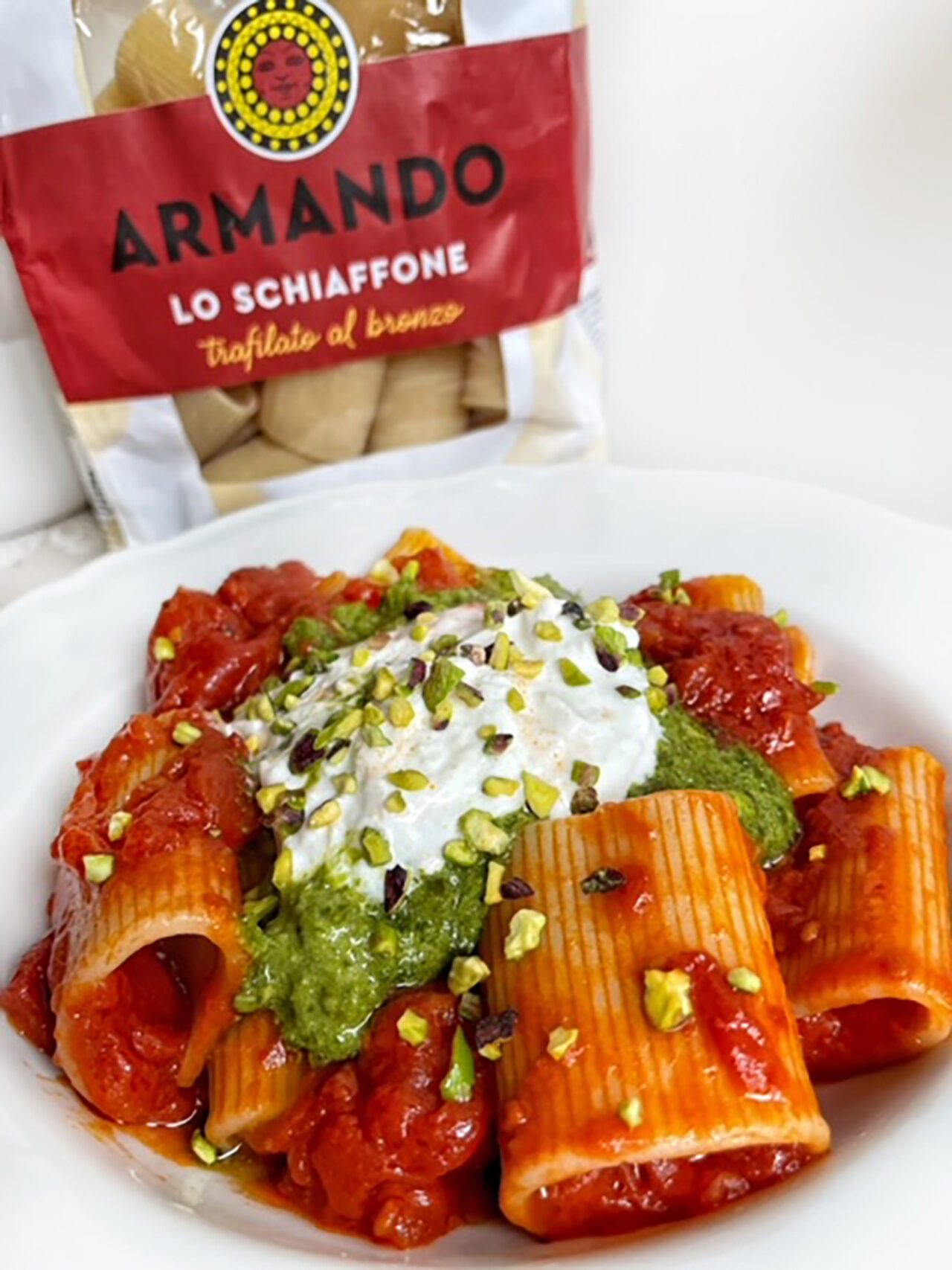 Schiaffoni al pomodoro con crescenza, pesto di basilico e granella di pistacchi