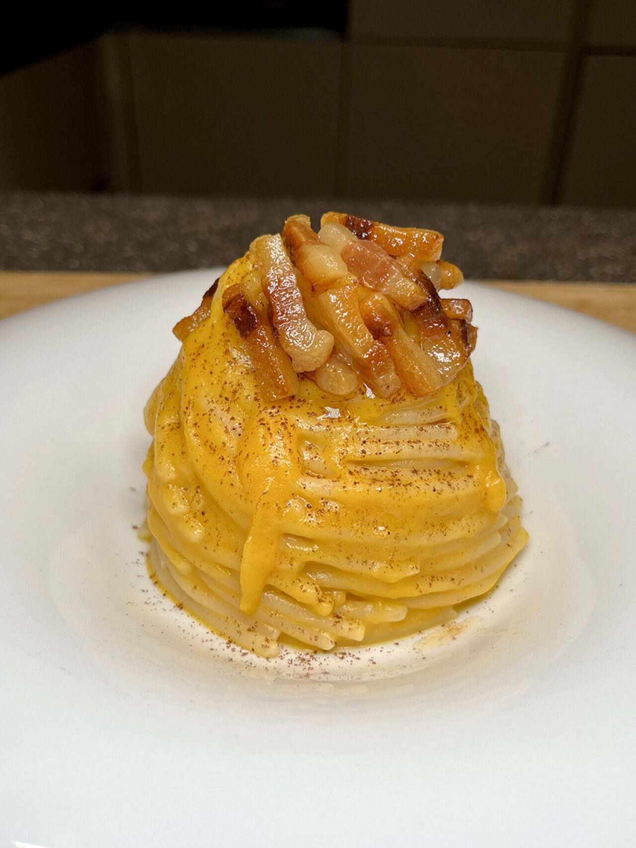 Spaghettone con crema di zucca, guanciale croccante e cacao