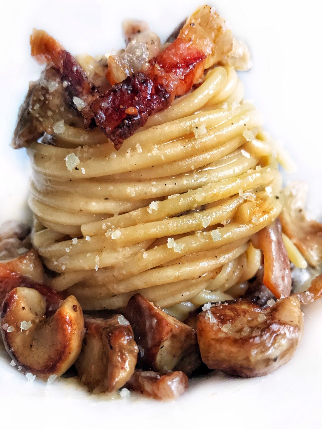 Spaghetti con funghi porcini, crema di pecorino, pepe nero e guanciale croccante