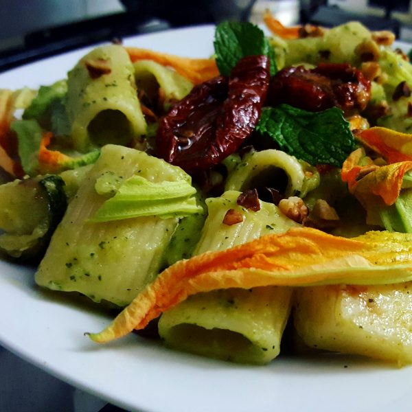 Mezze Maniche mit Zucchinipesto, getrockneten Tomaten, gerösteten Haselnüssen und Zucchiniblüten