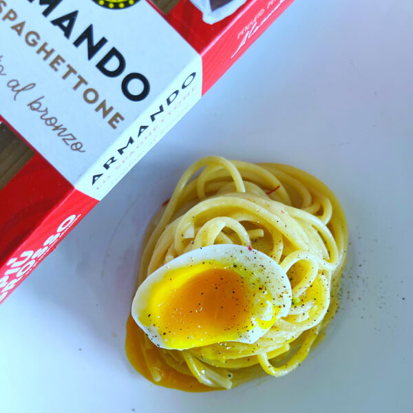 Piatto di pasta con uovo fondente e scalogno