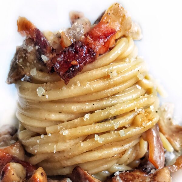 Spaghetti con funghi porcini, crema di pecorino, pepe nero e guanciale croccante